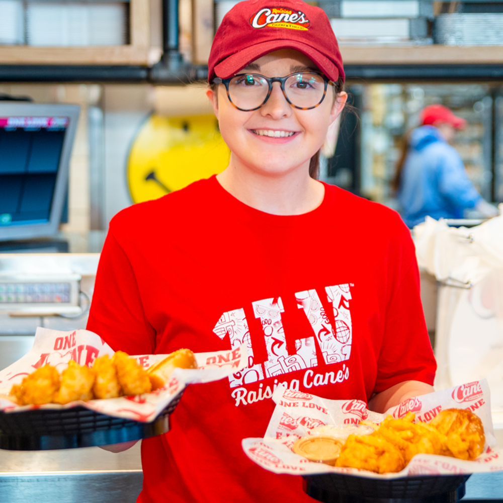Raising Cane's crew member serving food